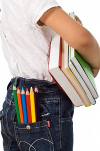 Back to school - kid with colorful books and pencils